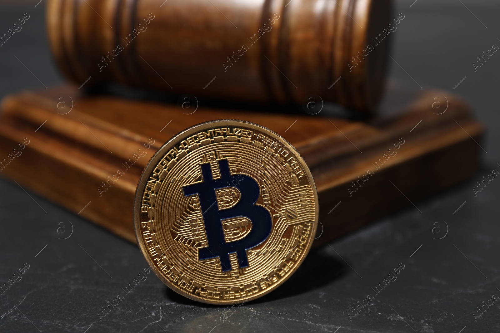 Cryptocurrency. Bitcoin and judge's gavel on black table, closeup Photo of Cryptocurrency. Bitcoin and judge's gavel on black table, closeup
