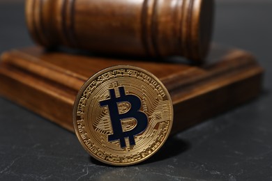 Photo of Cryptocurrency. Bitcoin and judge's gavel on black table, closeup