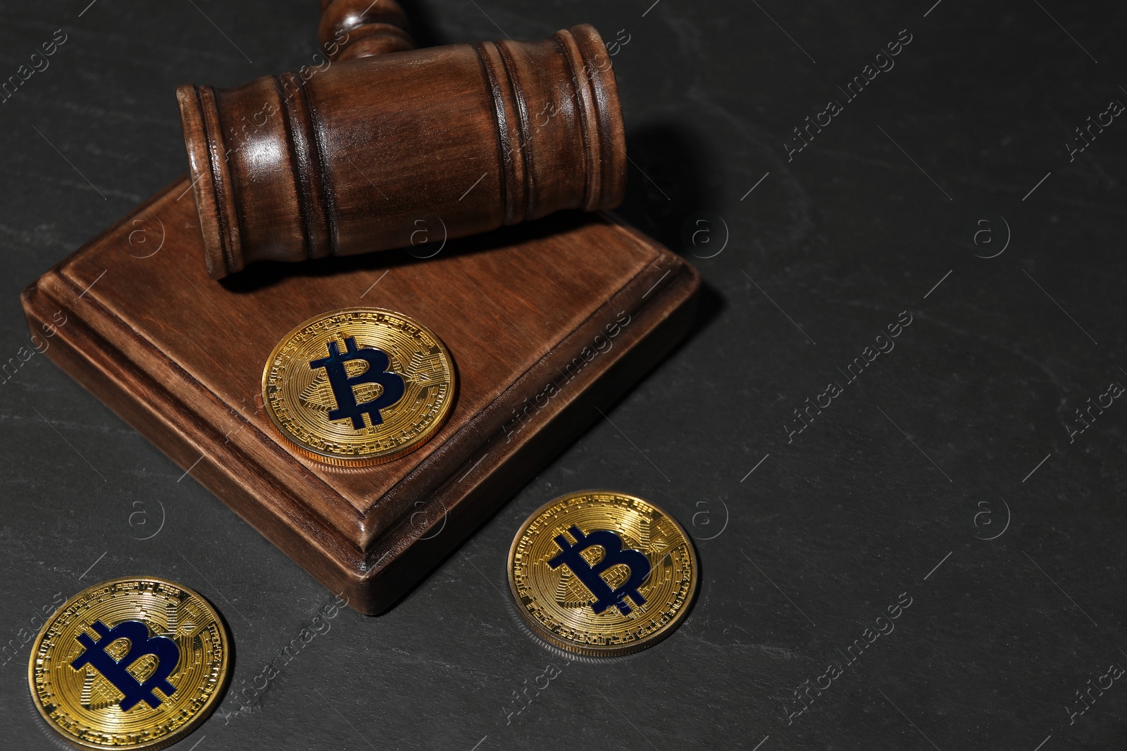 Photo of Cryptocurrency. Bitcoins and judge's gavel on black table, closeup. Space for text