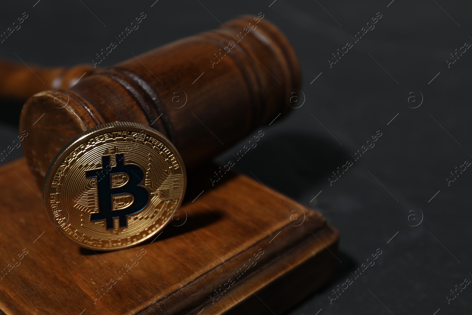 Photo of Cryptocurrency. Bitcoin and judge's gavel on black table, closeup. Space for text