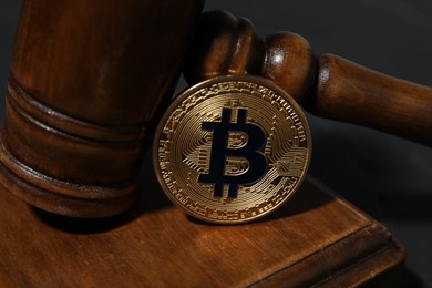 Photo of Cryptocurrency. Bitcoin and judge's gavel on black table, closeup