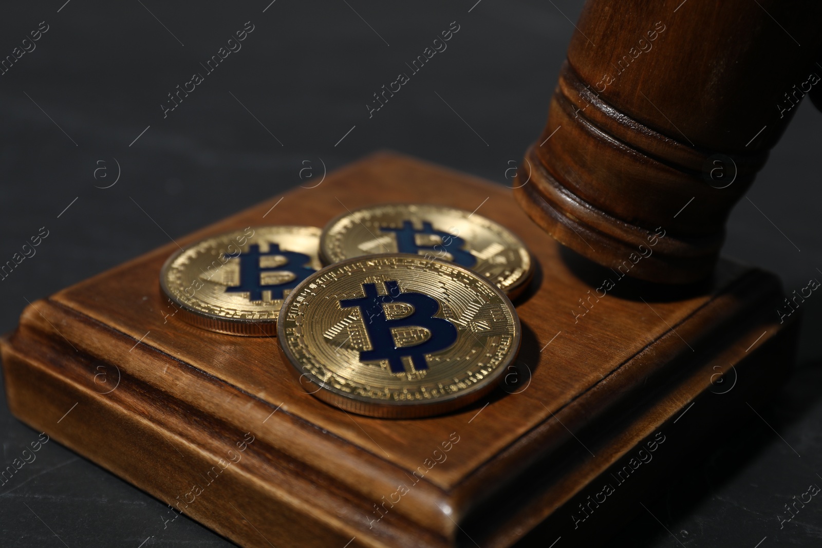 Cryptocurrency. Bitcoins and judge's gavel on black table, closeup Photo of Cryptocurrency. Bitcoins and judge's gavel on black table, closeup