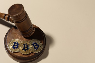 Photo of Cryptocurrency. Bitcoins and judge's gavel on beige background, above view. Space for text