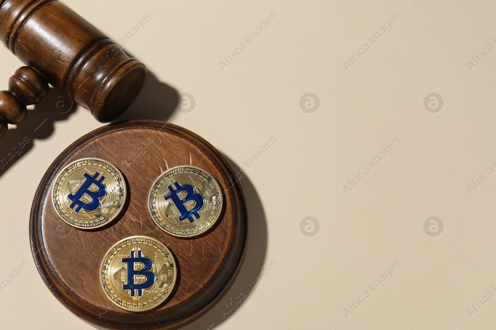 Photo of Cryptocurrency. Bitcoins and judge's gavel on beige background, flat lay. Space for text