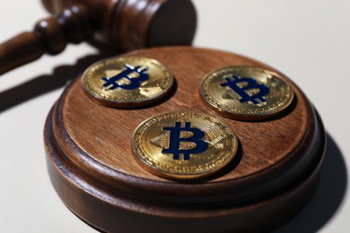 Photo of Cryptocurrency. Bitcoins and judge's gavel on beige background, closeup