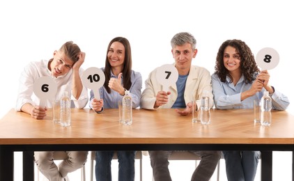 Photo of Panel of judges voting with score signs at table on white background