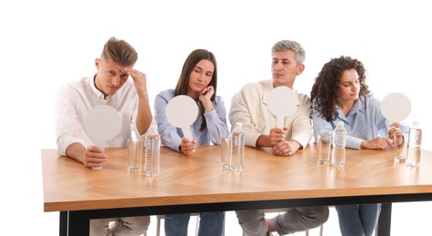 Photo of Panel of judges with blank score signs at table on white background