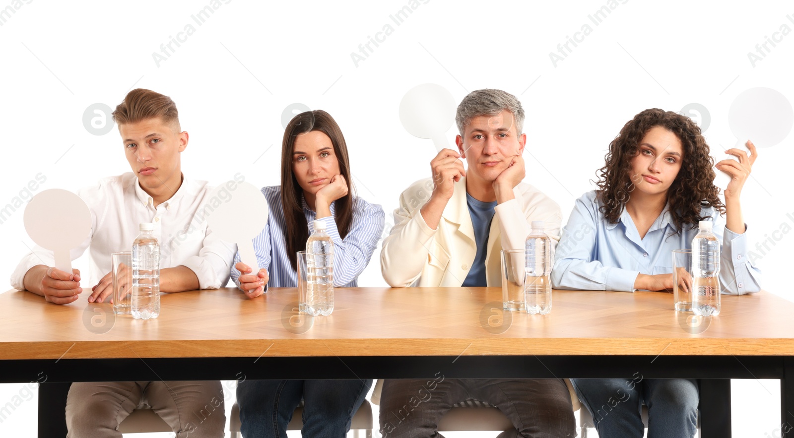 Panel of judges with blank score signs at table on white background Photo of Panel of judges with blank score signs at table on white background