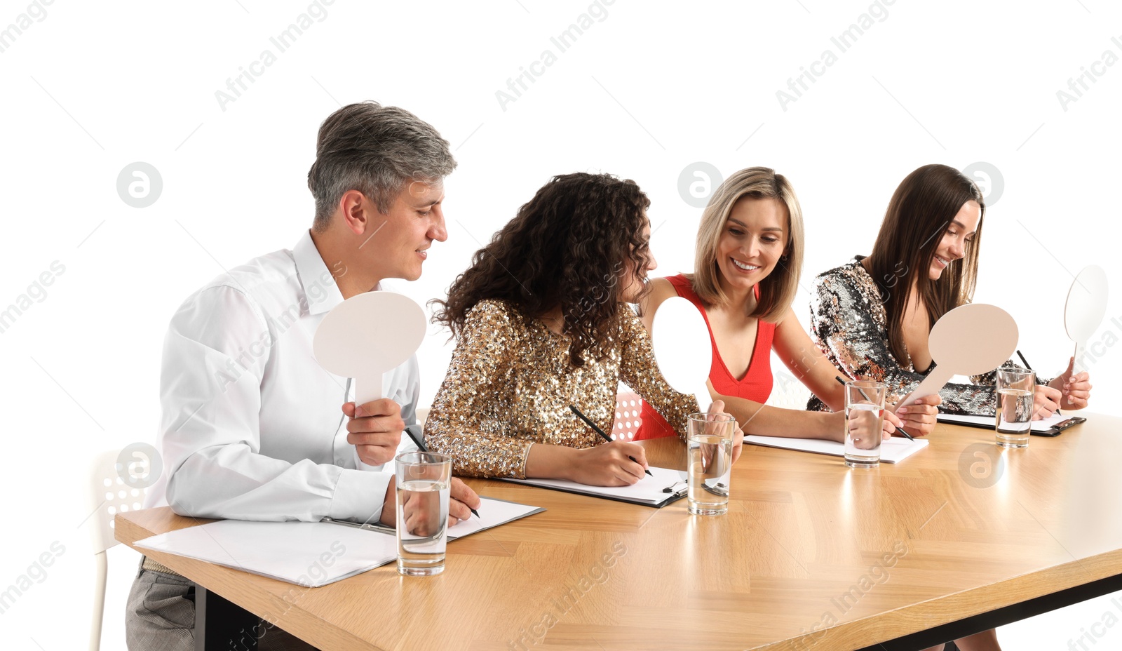 Panel of judges with blank score signs at table on white background Photo of Panel of judges with blank score signs at table on white background