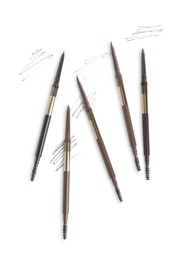 Photo of Eyebrow pencils and strokes isolated on white, top view