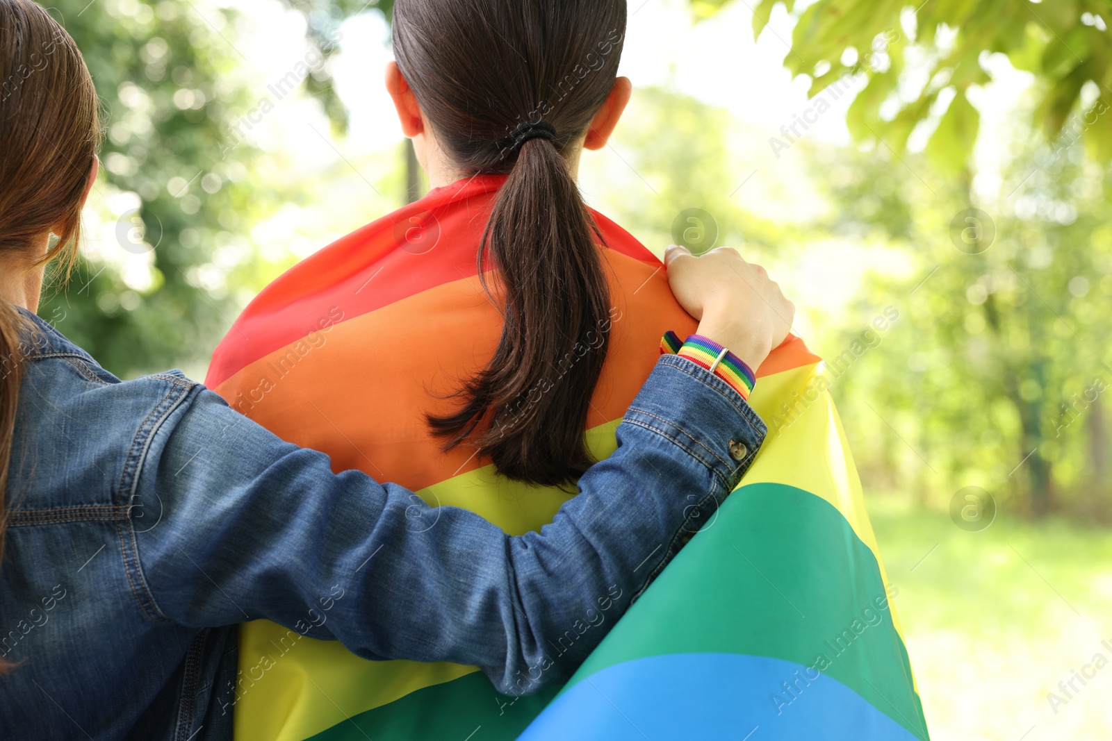 LGBT concept. Women with rainbow flag outdoors, closeup Photo of LGBT concept. Women with rainbow flag outdoors, closeup