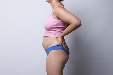 Photo of Liposuction. Woman in underwear on light grey background, closeup