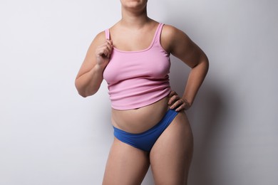 Photo of Liposuction. Woman in underwear on light grey background, closeup