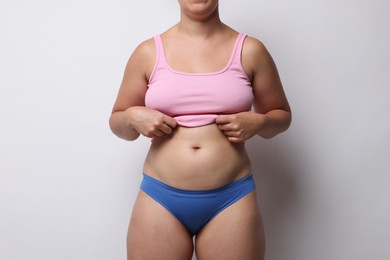 Photo of Liposuction. Woman in underwear on light grey background, closeup