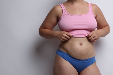 Photo of Liposuction. Woman in underwear on light grey background, closeup. Space for text