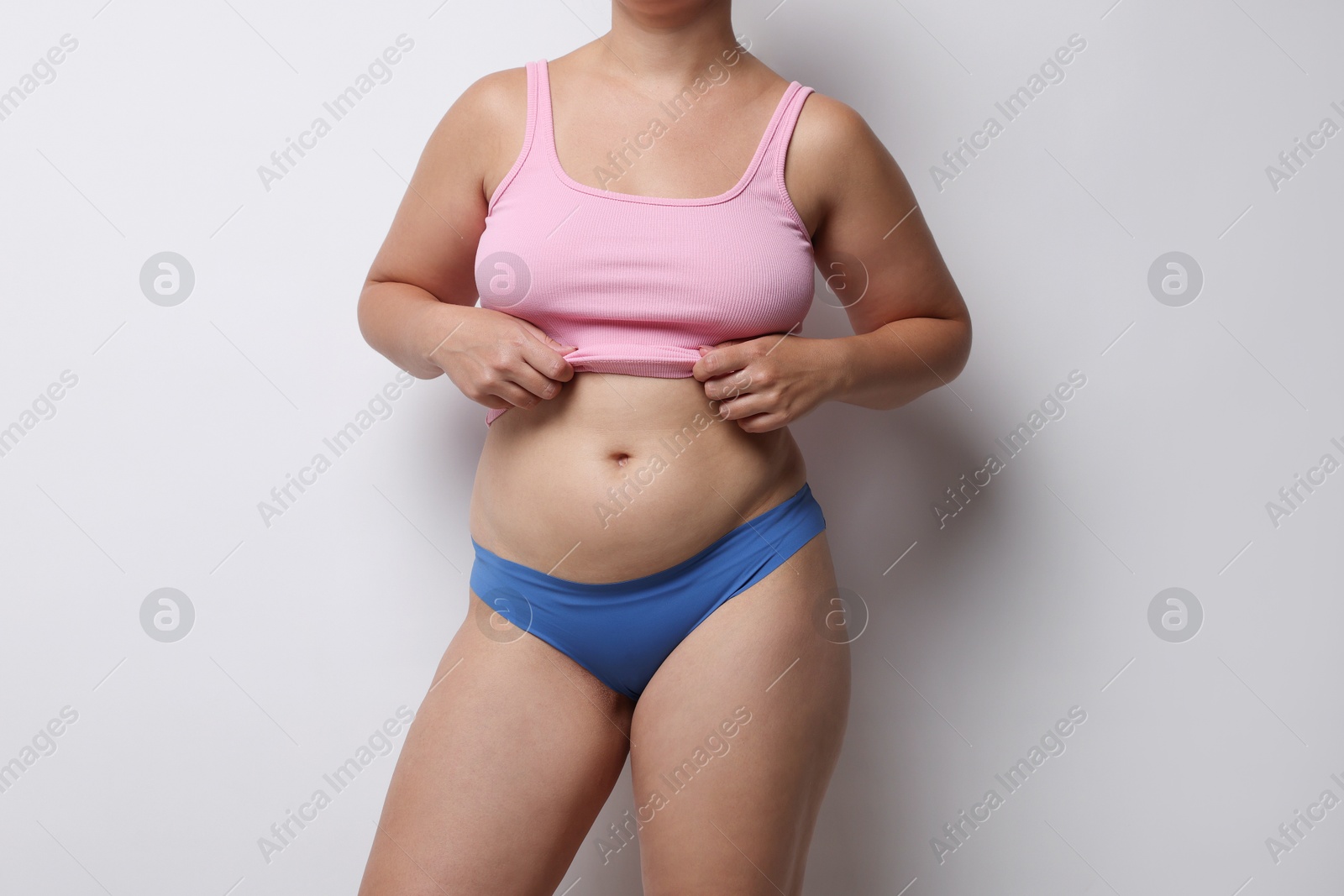 Photo of Liposuction. Woman in underwear on light grey background, closeup