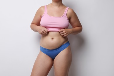 Photo of Liposuction. Woman in underwear on light grey background, closeup