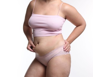 Photo of Liposuction. Woman in underwear touching her belly on white background, closeup