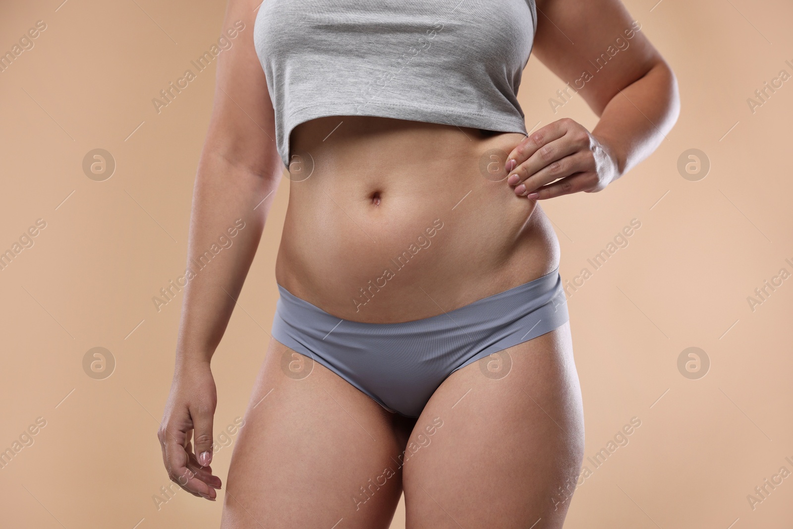 Liposuction. Woman in underwear touching her belly on beige background, closeup Photo of Liposuction. Woman in underwear touching her belly on beige background, closeup