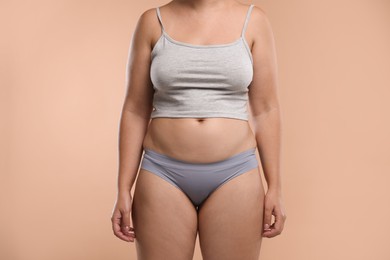 Photo of Liposuction. Woman in underwear on beige background, closeup