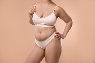Photo of Liposuction. Woman in underwear on beige background, closeup