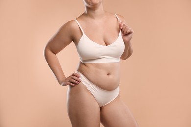 Photo of Liposuction. Woman in underwear on beige background, closeup
