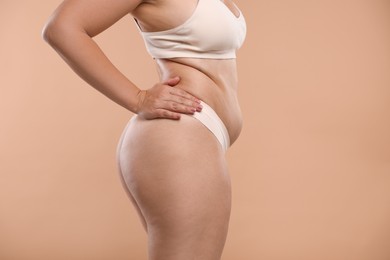 Photo of Liposuction. Woman in underwear on beige background, closeup