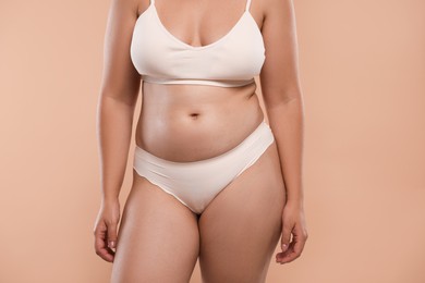 Photo of Liposuction. Woman in underwear on beige background, closeup