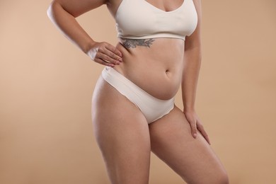 Photo of Liposuction. Woman in underwear on beige background, closeup