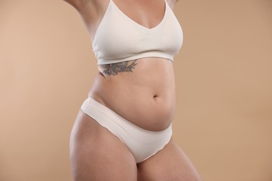 Photo of Liposuction. Woman in underwear on beige background, closeup