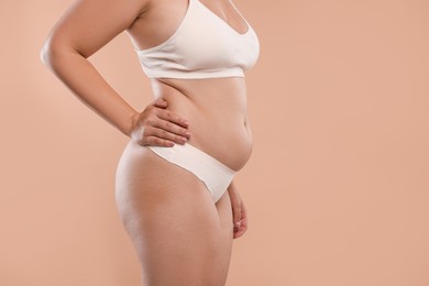 Photo of Liposuction. Woman in underwear on beige background, closeup