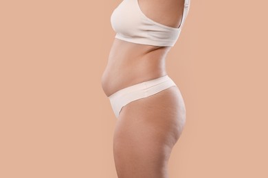 Photo of Liposuction. Woman in underwear on beige background, closeup