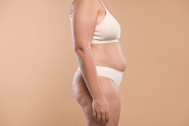 Photo of Liposuction. Woman in underwear on beige background, closeup
