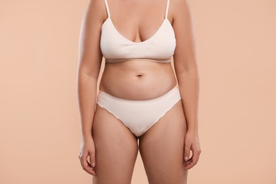 Photo of Liposuction. Woman in underwear on beige background, closeup