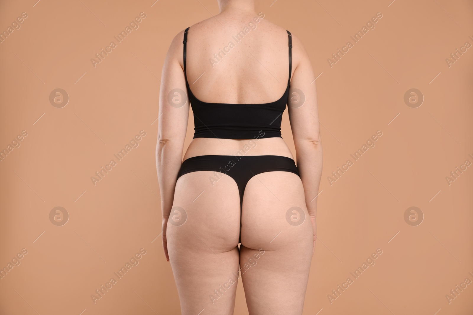 Photo of Liposuction. Woman in underwear on beige background, back view