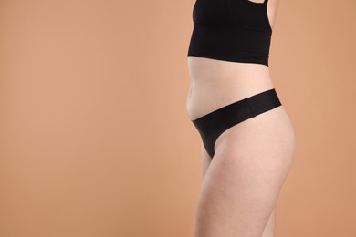 Photo of Liposuction. Woman in underwear on beige background, closeup. Space for text