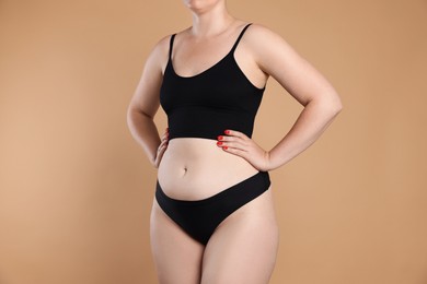 Photo of Liposuction. Woman in underwear on beige background, closeup