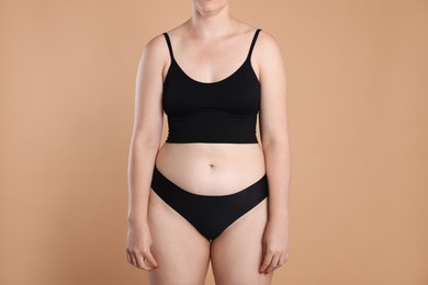 Photo of Liposuction. Woman in underwear on beige background, closeup