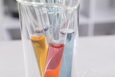 Photo of Test tubes with different samples on table in laboratory, closeup. Solution chemistry
