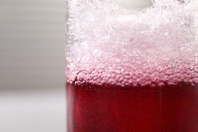 Photo of Solution chemistry. Beaker with sample on blurred background, closeup. Space for text