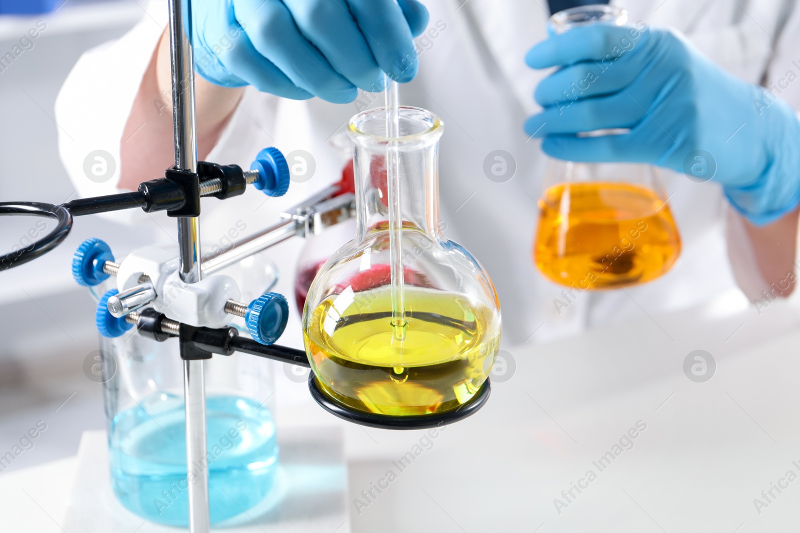Photo of Scientist working with different samples in laboratory, closeup. Solution chemistry