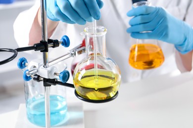 Photo of Scientist working with different samples in laboratory, closeup. Solution chemistry