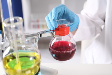 Photo of Scientist working with different samples in laboratory, closeup. Solution chemistry
