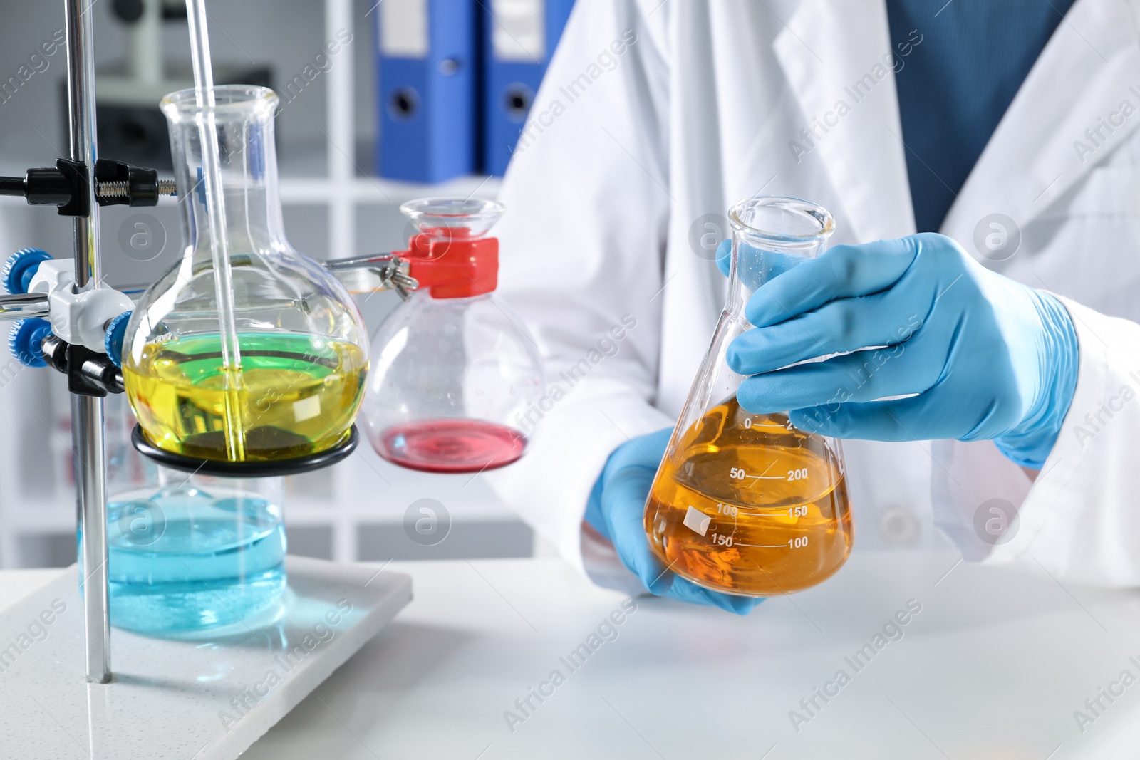 Photo of Scientist working with different samples at white table in laboratory, closeup. Solution chemistry