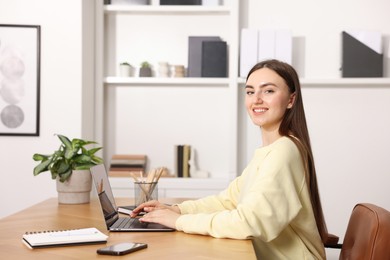 Photo of Copywriter using laptop at wooden table indoors