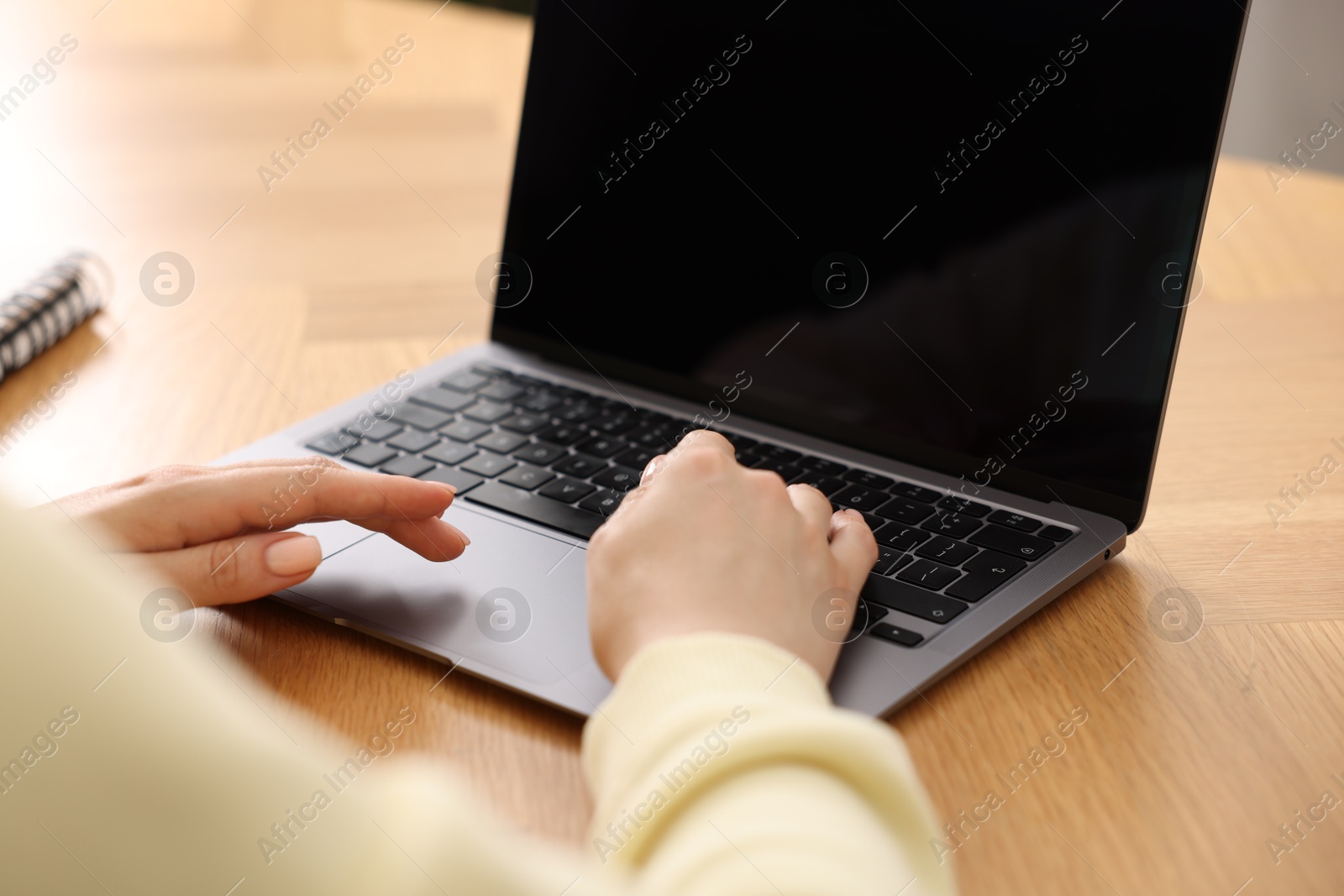 Copywriter using laptop at wooden table indoors, closeup Photo of Copywriter using laptop at wooden table indoors, closeup