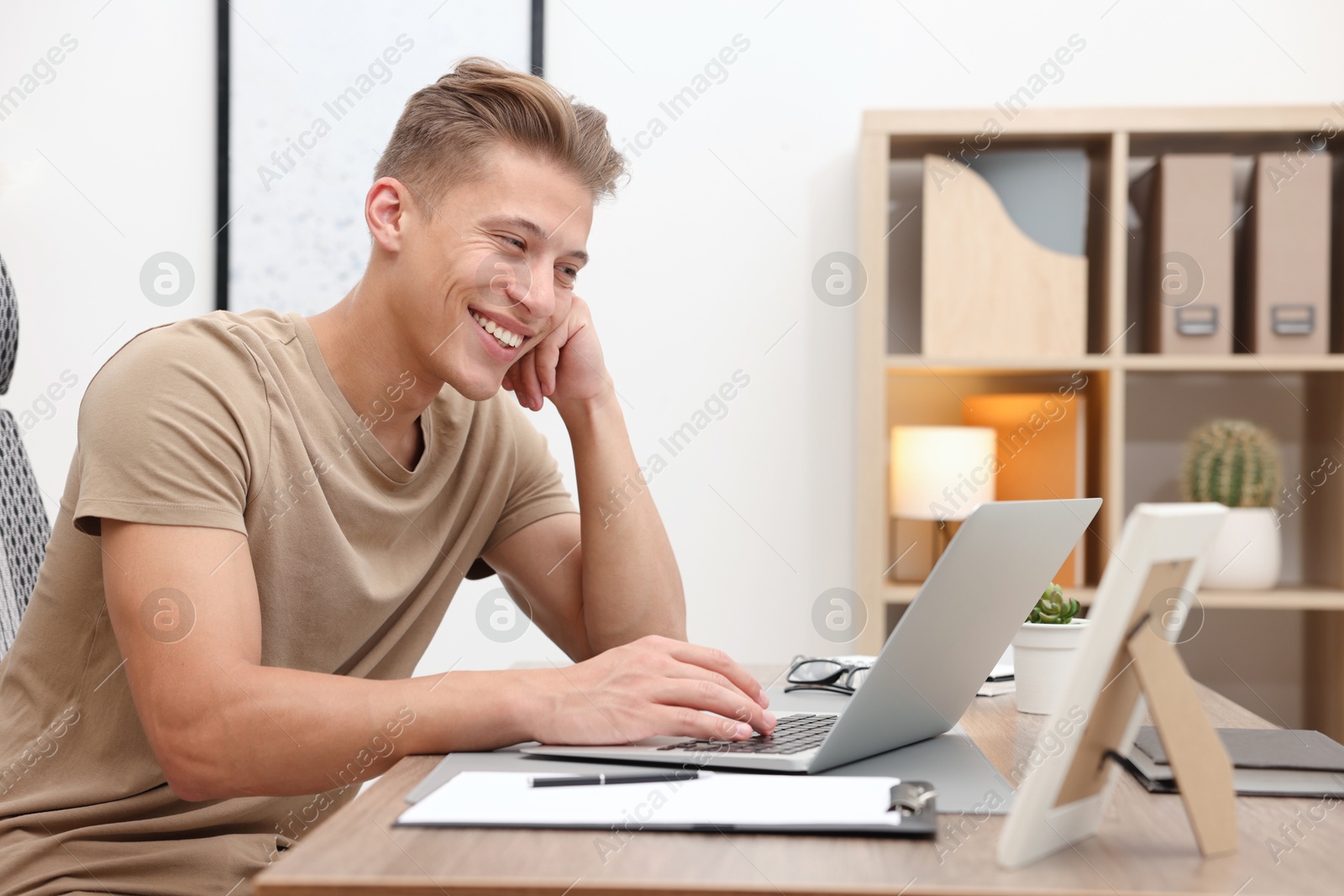 Photo of Copywriter using laptop at wooden table indoors