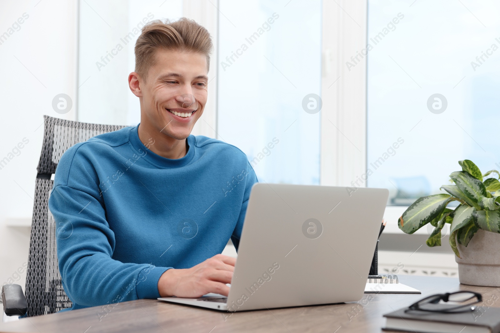 Copywriter using laptop at wooden table indoors Photo of Copywriter using laptop at wooden table indoors