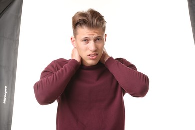 Photo of Young man suffering from neck pain on white background