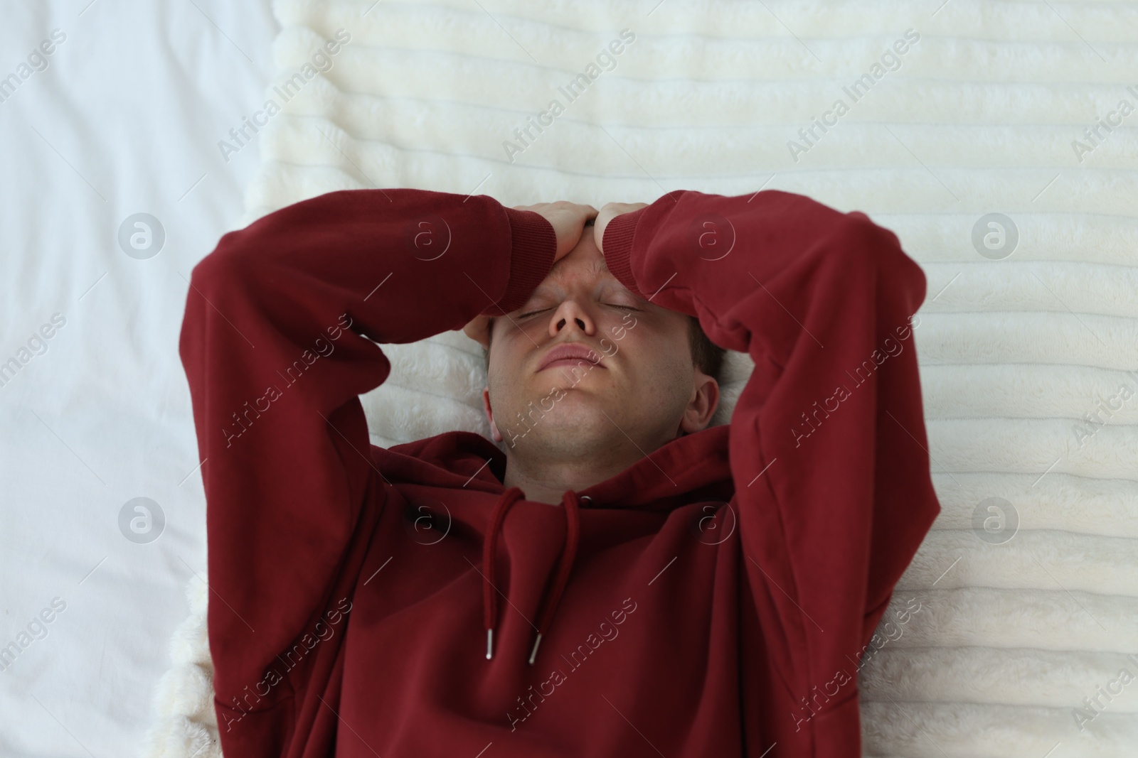 Sad tired man lying on bed, above view. Depression Photo of Sad tired man lying on bed, above view. Depression